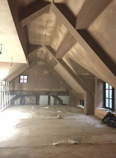 Plastered pitched ceiling with exposed beam shapes