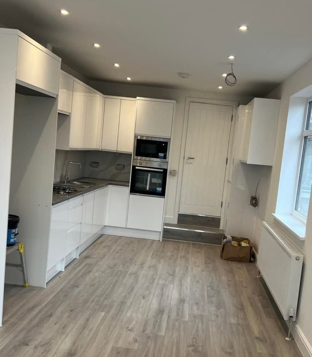 White kitchen cabinets with wood-effect flooring